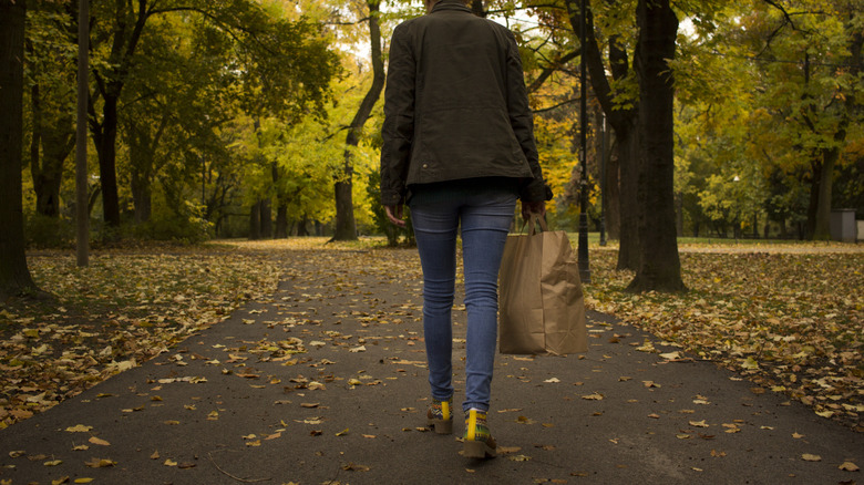 Woman in skinny jeans walking outside in fall