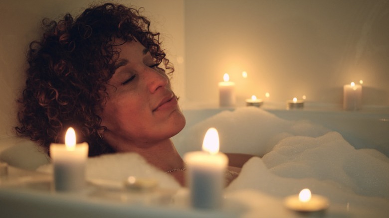 Woman in candle-lit bathtub