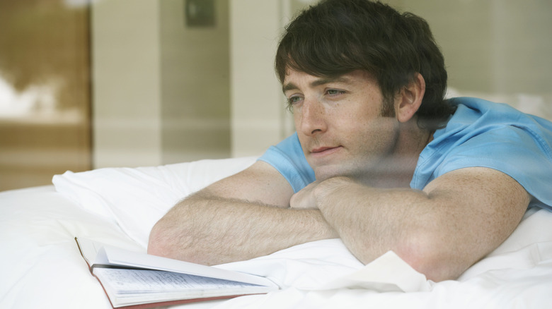 Man in bed with journal