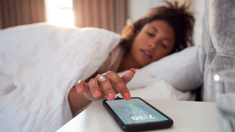 Woman waking up with phone