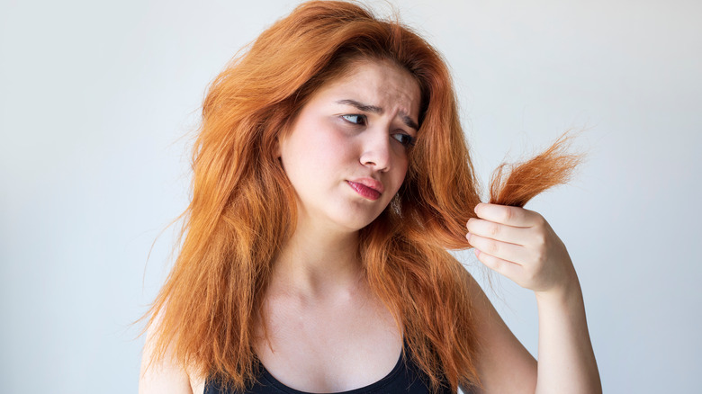 woman looking at damaged hair