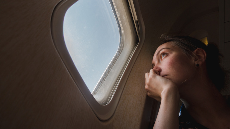 woman looking out plane window