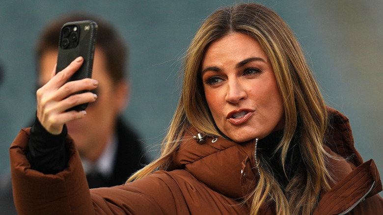 Erin Andrews taking a selfie in a brown ski suit