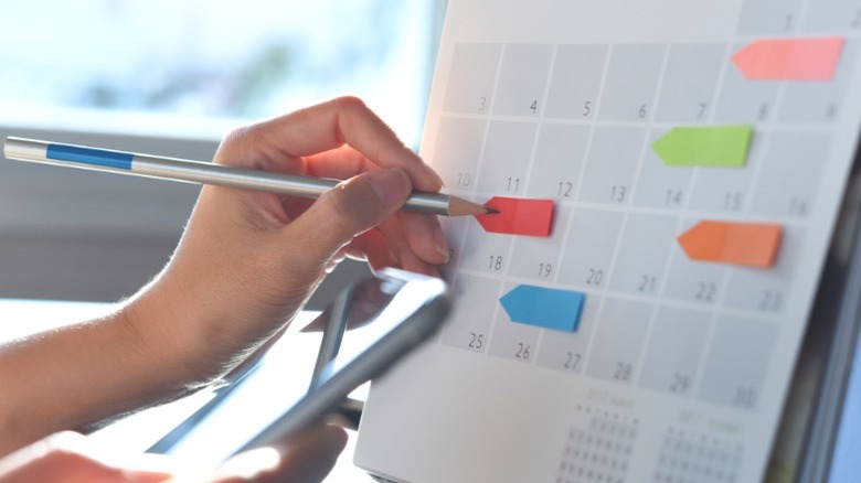 Woman's hand writing on calendar