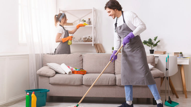 couple cleaning living room