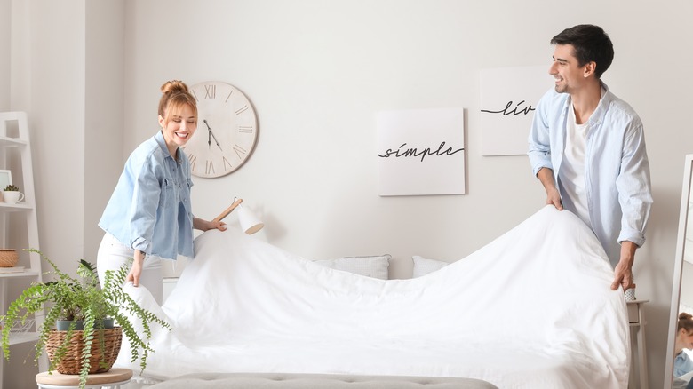 smiling couple making bed