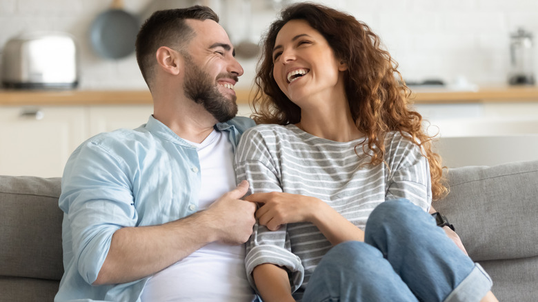 laughing couple on sofa