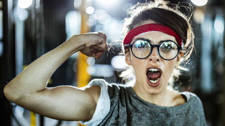 Woman sweating and flexing muscles
