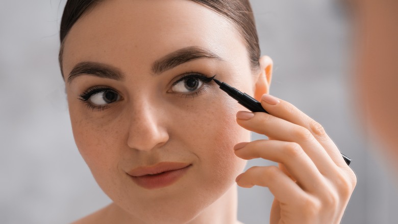 Woman applying liquid liner