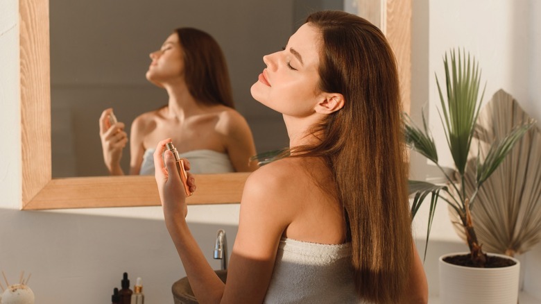 woman putting on perfume