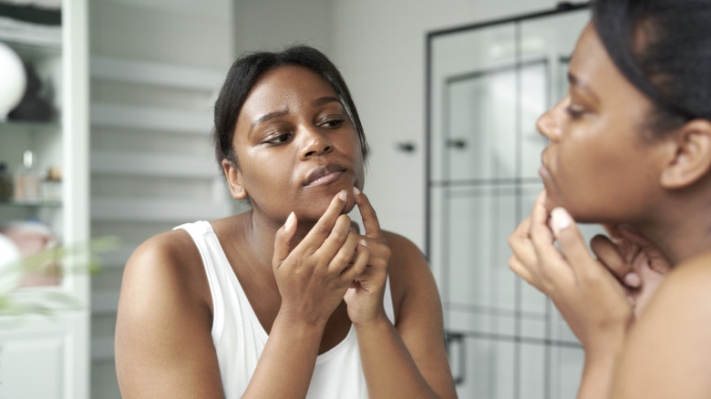 woman looking at chin pimple