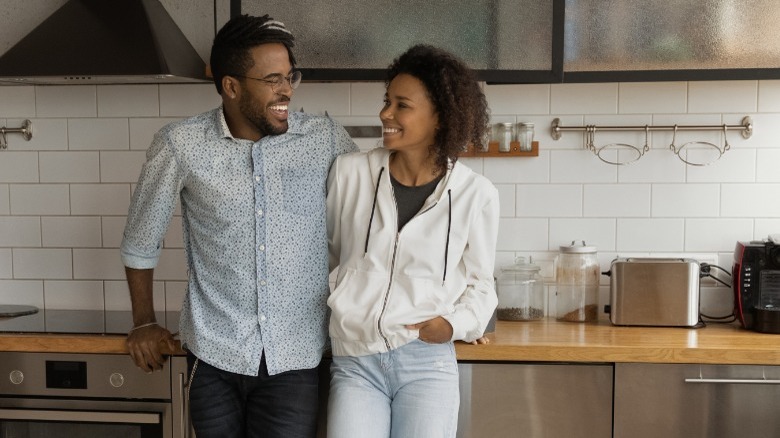 Black couple standing in kitchen