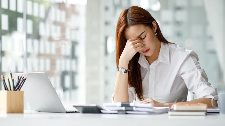 Woman at desk looking stressed