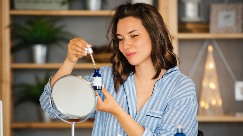 woman looking at skincare serum