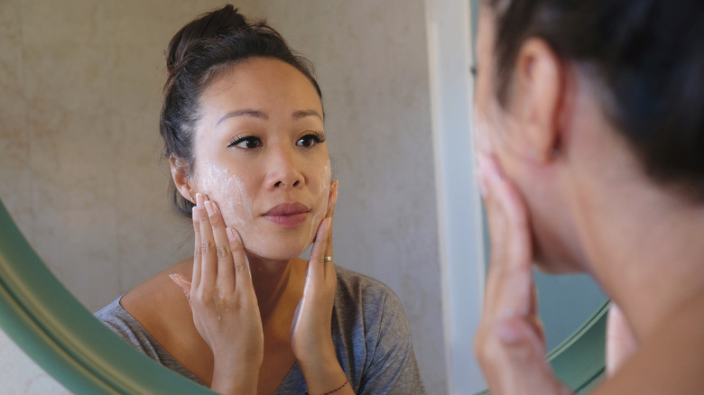 A woman exfoliating her face