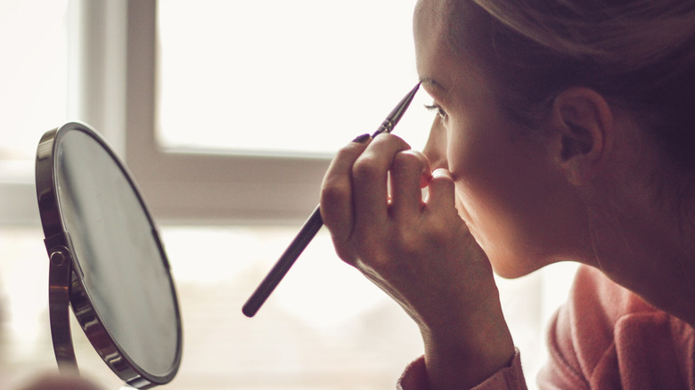 Woman filling in her eyebrows