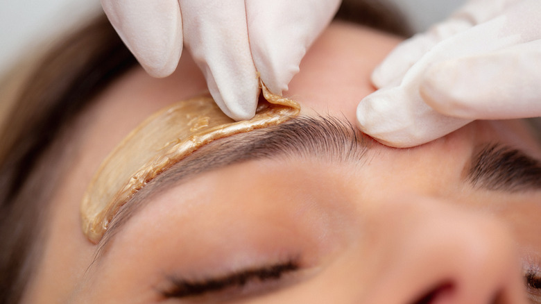 Woman getting her eyebrows waxed