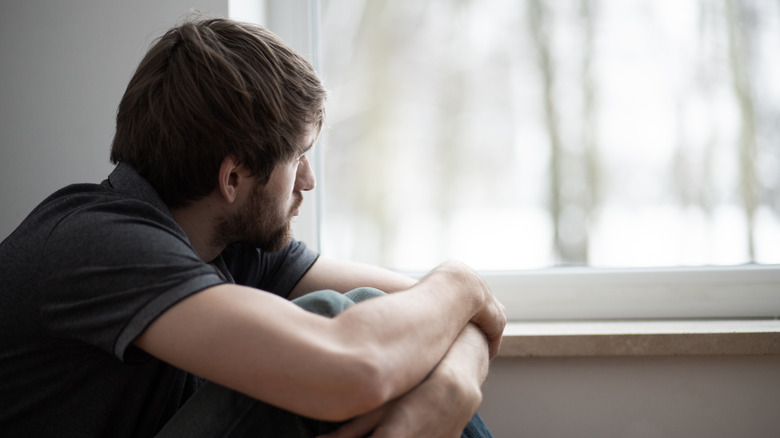 Sad man looking out window