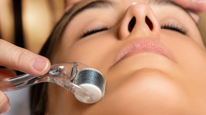 Woman microneedling her face