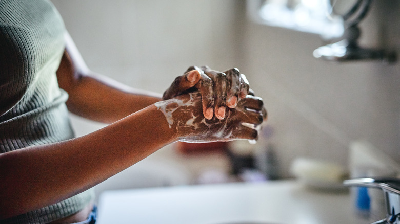 woman washing hands with soap
