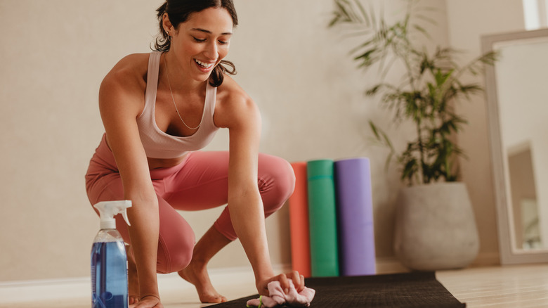 woman cleaning yoga mat