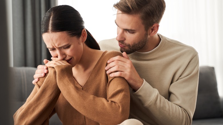 Man comforting crying woman