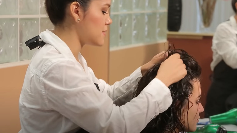 Hairstylist scrunching hair with gel