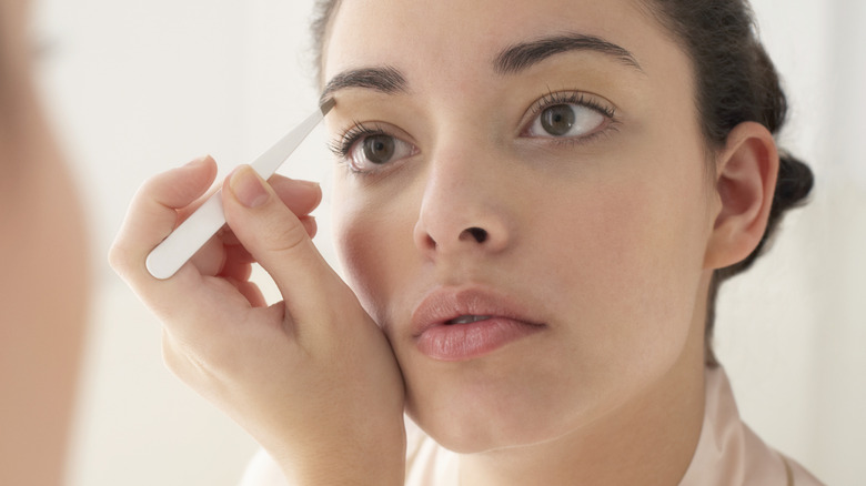 person plucking eyebrow