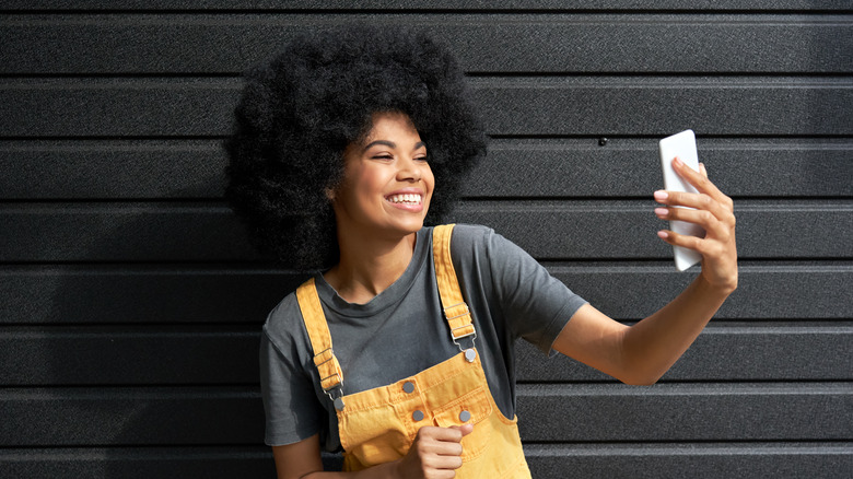 woman smiling at her phone