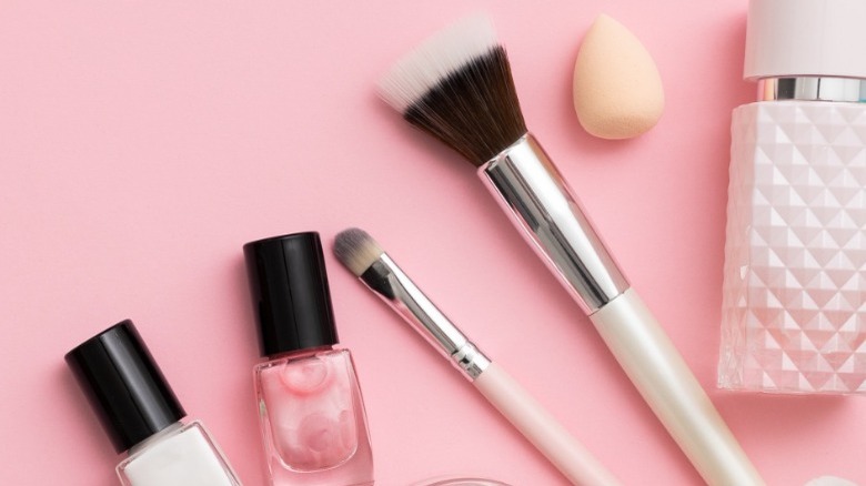 makeup brushes and beauty products laying on table