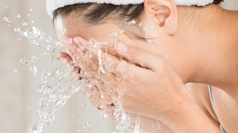 woman washing face with water