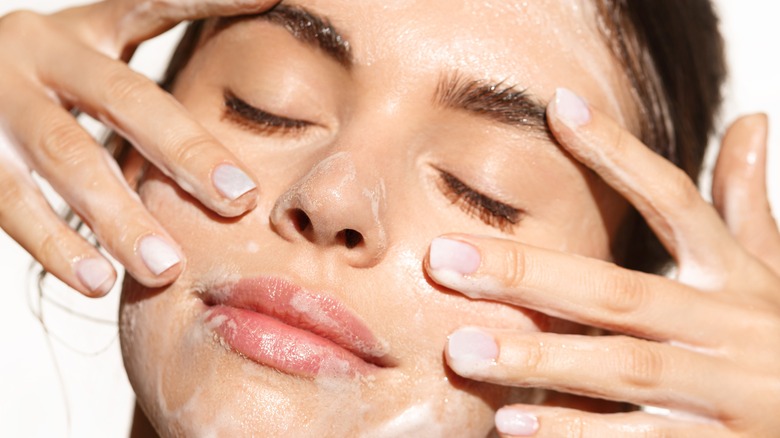 woman rubbing gel cleanser on face