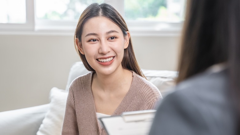 smiling woman talking to therapist
