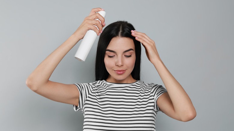 woman holding dry shampoo bottle