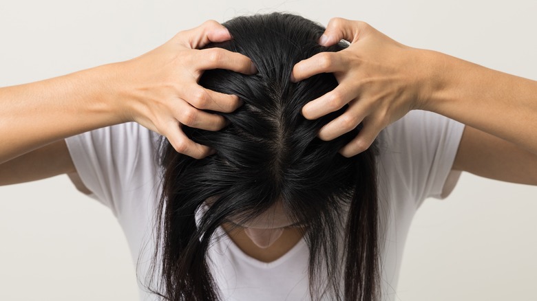 woman rubbing in dry shampoo