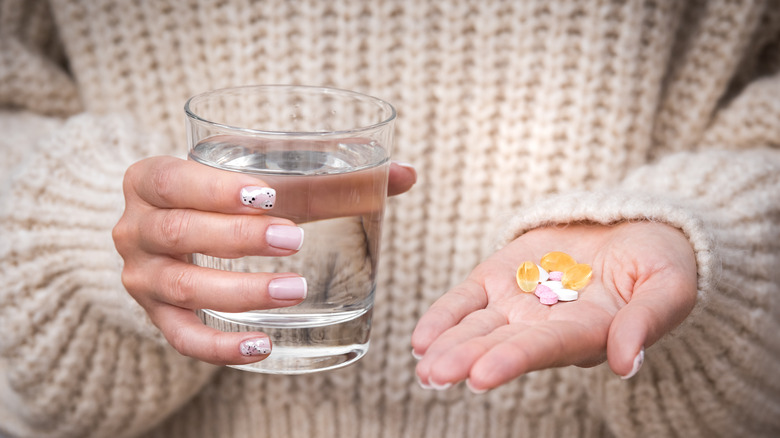 woman holding multivitamins and supplements