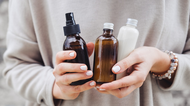 female hands holding skincare bottles