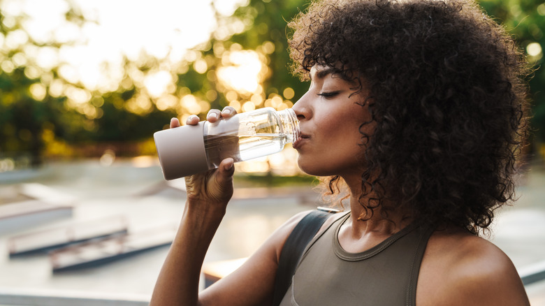 woman drinking water outside