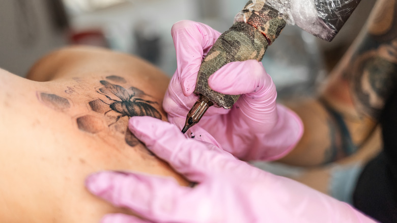 Woman sitting for back tattoo