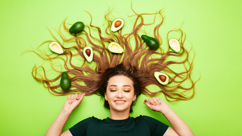 Avocados surrounding woman's hair