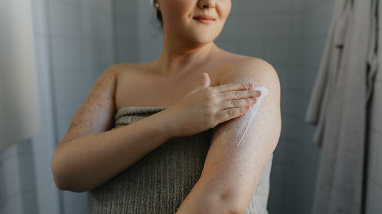 woman applying body lotion 