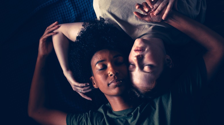 couple lying down holding hands