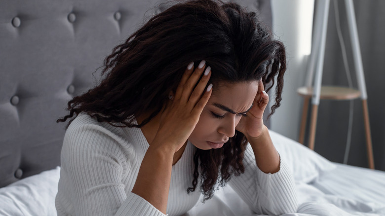 hungover woman holding head