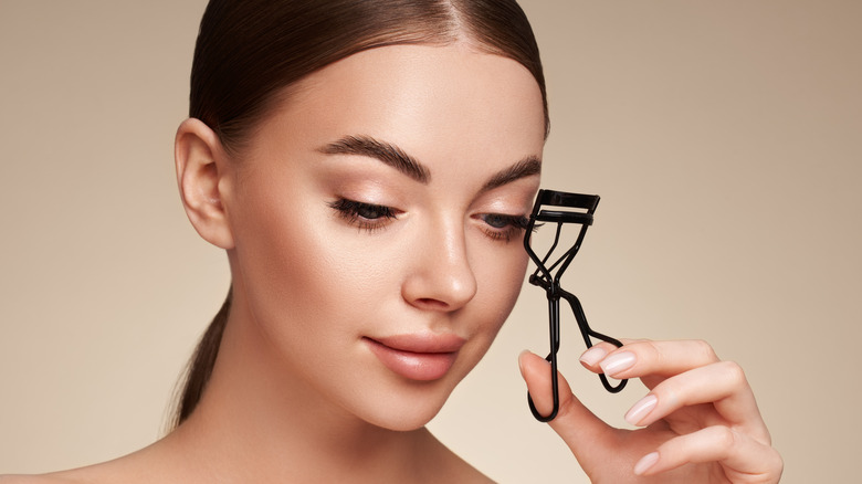 woman using eyelash curler