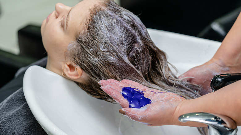 Woman getting purple shampoo at salon