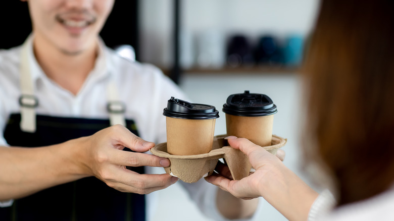 person buying cups of coffee 