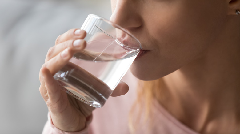 woman drinking water from glass