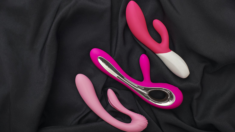 Pink vibrators displayed on black sheet