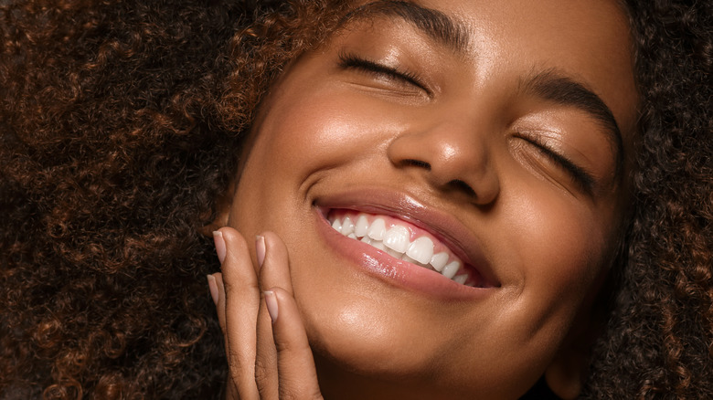 closeup of woman touching face