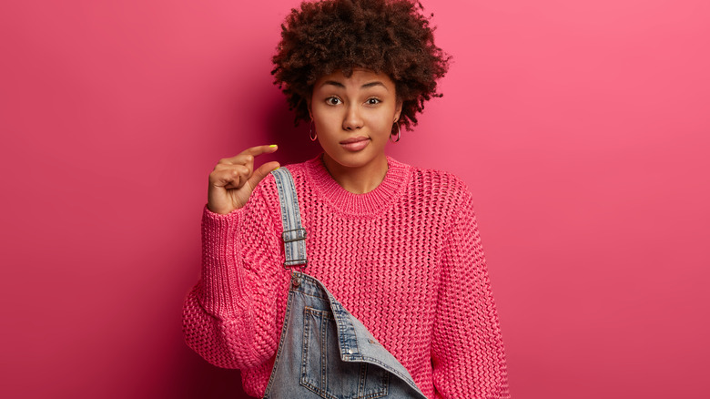 Woman pairs sweater with overalls